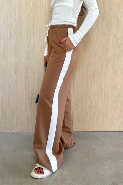 Denver Pant Tan by Sneaky Link, relaxed fit with elastic waist, contrast side stripe, and drawstring for a sporty look. Made from polyester blend. Cold hand wash. Size down if between sizes.