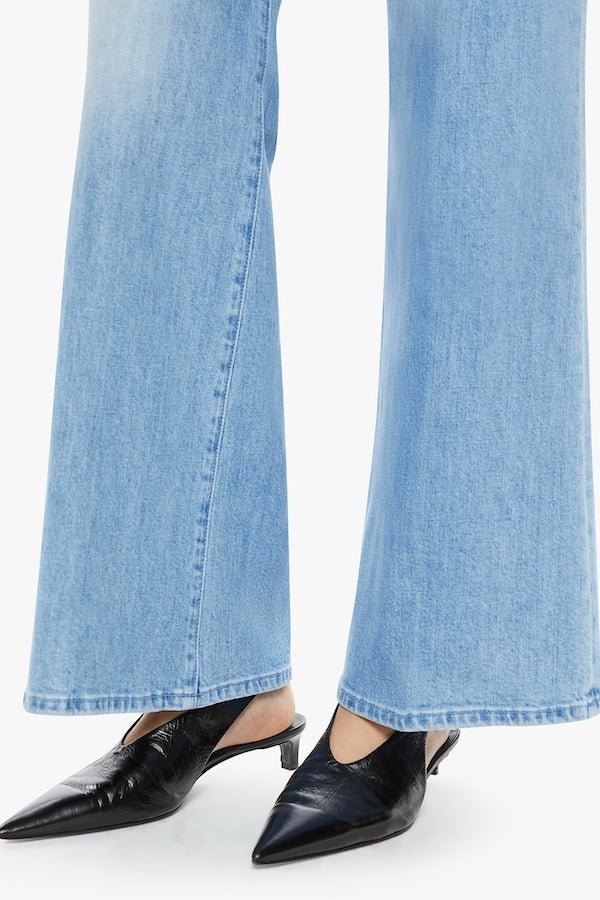 The Tomcat Roller Skimp Puzzled by MOTHER, trendy high-waisted wide-leg jeans with a button fly and light blue wash. Perfect for a relaxed, stylish look with whiskering and fading at the knees.
