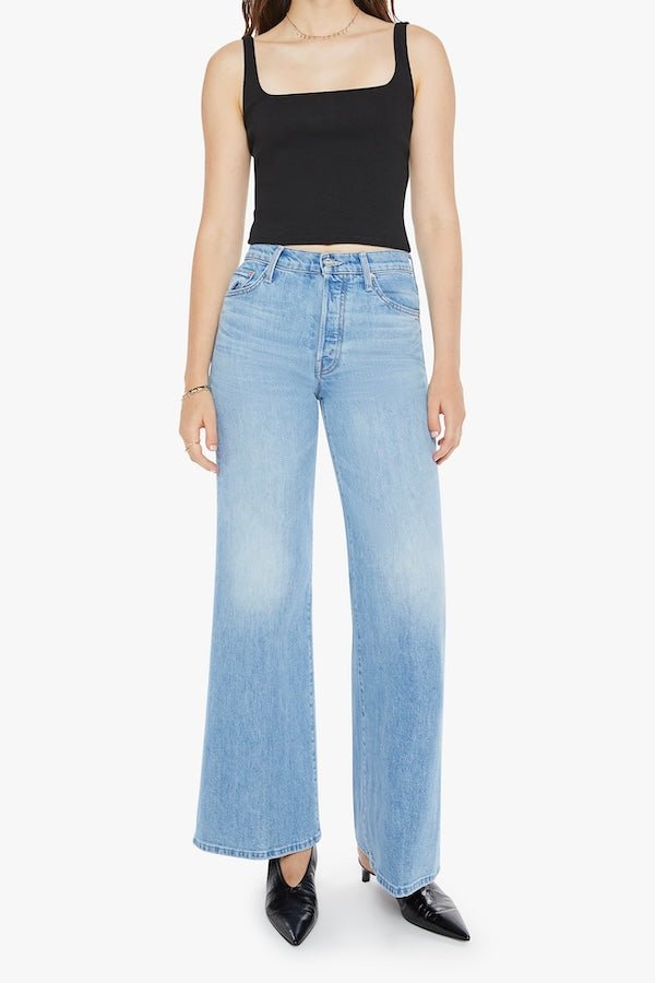 The Tomcat Roller Skimp Puzzled by MOTHER, trendy high-waisted wide-leg jeans with a button fly and light blue wash. Perfect for a relaxed, stylish look with whiskering and fading at the knees.