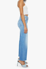 The Rambler Zip Flood Read Between The Lines by MOTHER, trendy high-waisted jeans with a wide straight leg, whiskering, and fading. Perfect for a stylish and comfortable look in a mid-blue wash.