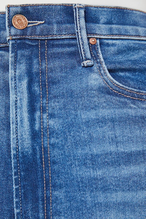 The Maven Ankle Fray Bitchin' by MOTHER, trendy high-rise jeans with a loose fit, wide leg, and frayed hem. Perfect for a relaxed, stylish look with mid-blue whiskering and fading at the knee.