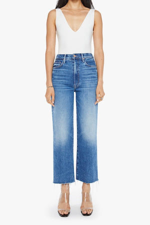 The Maven Ankle Fray Bitchin' by MOTHER, trendy high-rise jeans with a loose fit, wide leg, and frayed hem. Perfect for a relaxed, stylish look with mid-blue whiskering and fading at the knee.
