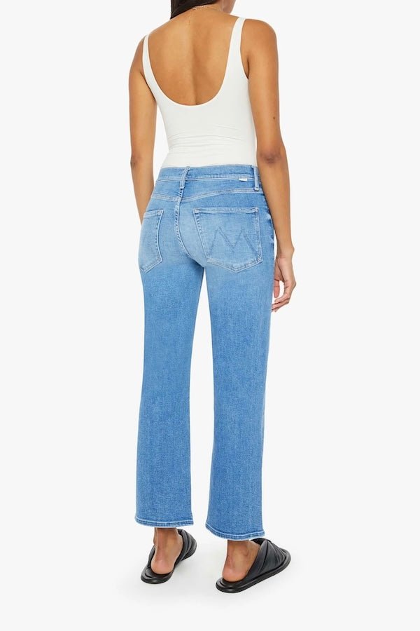 The Mid Rise Zip Rambler Ankle Out Of The Blue by MOTHER, trendy mid-rise jeans with a wide straight leg and ankle-length inseam. Perfect for a relaxed, stylish look with whiskering and fading at the knee.