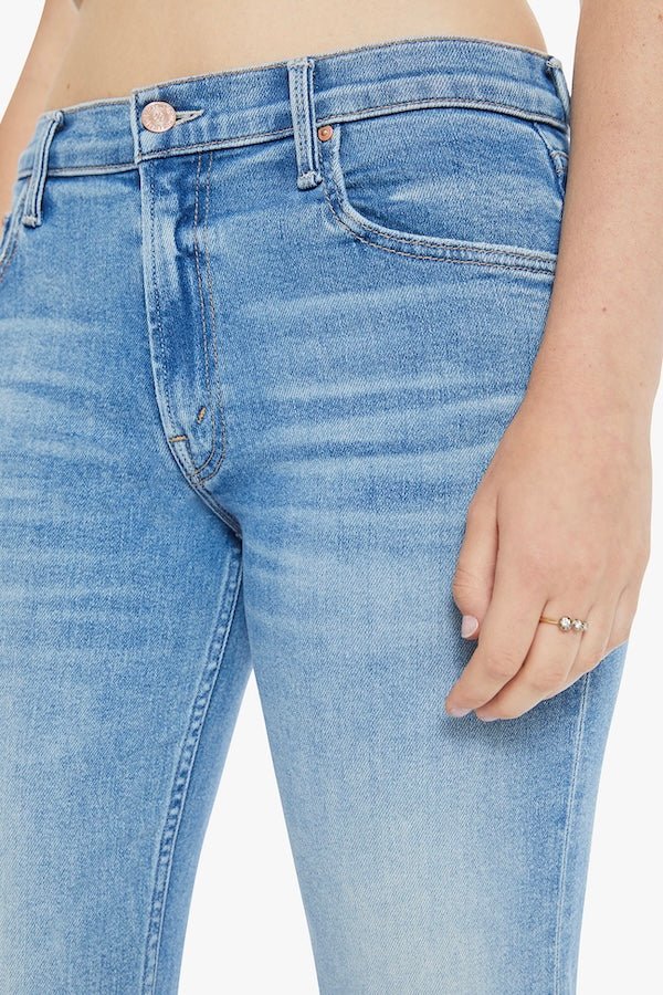 The Bookie Sneak Eye Of The Tiger by MOTHER, trendy high-rise bootcut jeans with a fitted hip and looser leg. Perfect for a relaxed, stylish look with whiskering and fading at the knees.