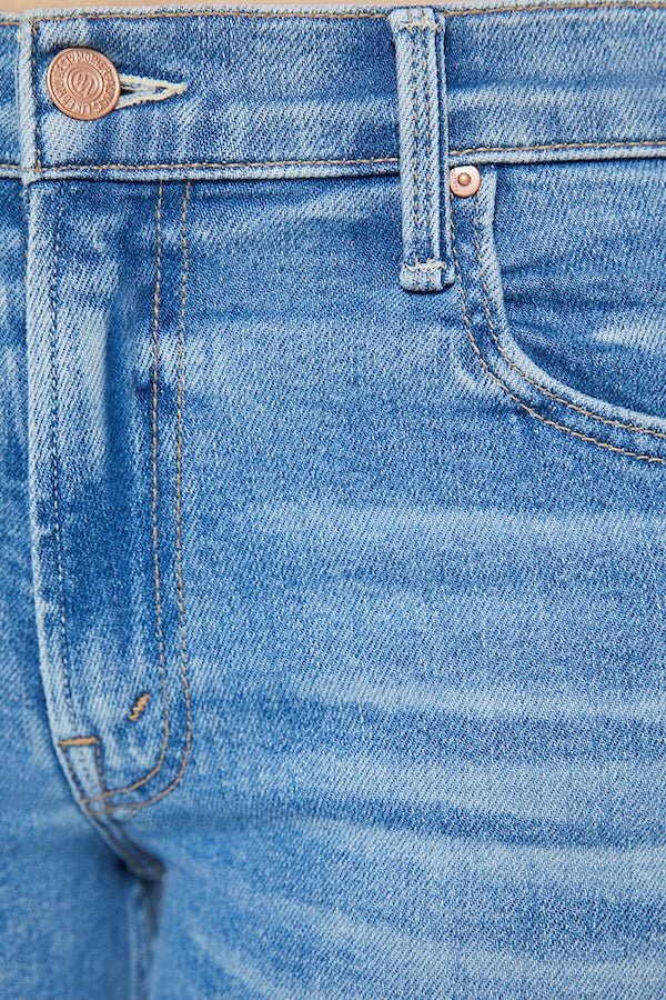 The Bookie Sneak Eye Of The Tiger by MOTHER, trendy high-rise bootcut jeans with a fitted hip and looser leg. Perfect for a relaxed, stylish look with whiskering and fading at the knees.