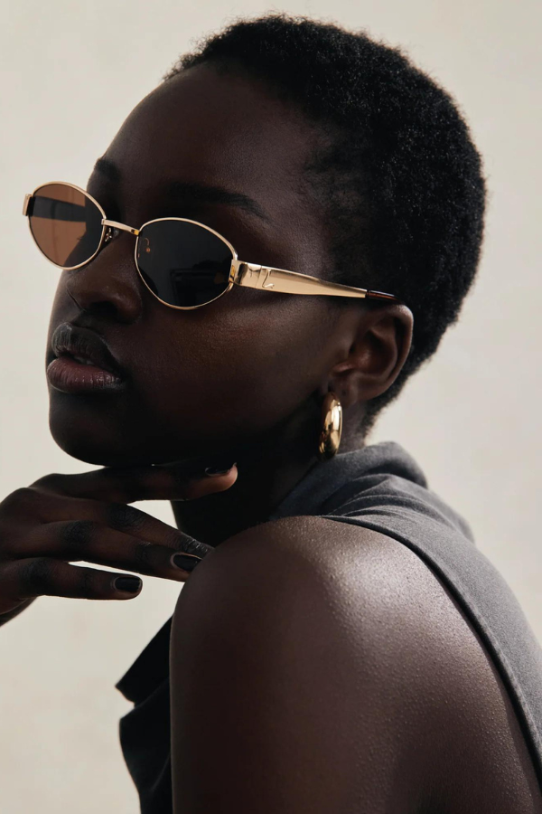 MU 52YS Brass Gold w, dark brown by Miu Miu, oval metal frame in pale gold with grey gradient polyamide lenses, narrow fit, high bridge nosepads for style and comfort.