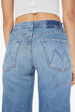 The Mid Rise Tunnel Vision Sneak I'm A Winner by MOTHER, trendy mid-rise jeans with a loose straight leg, featuring whiskering and fading at the knees. Perfect for a relaxed yet stylish look in a semi-rigid denim that softens with wear.