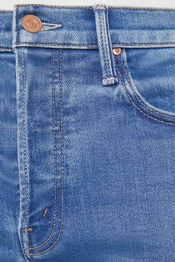 The Tomcat Ankle Piece By Piece by MOTHER, trendy high-rise jeans with a straight leg, button fly, and ankle-length inseam. Perfect for a stylish, everyday look with subtle whiskering and fading.