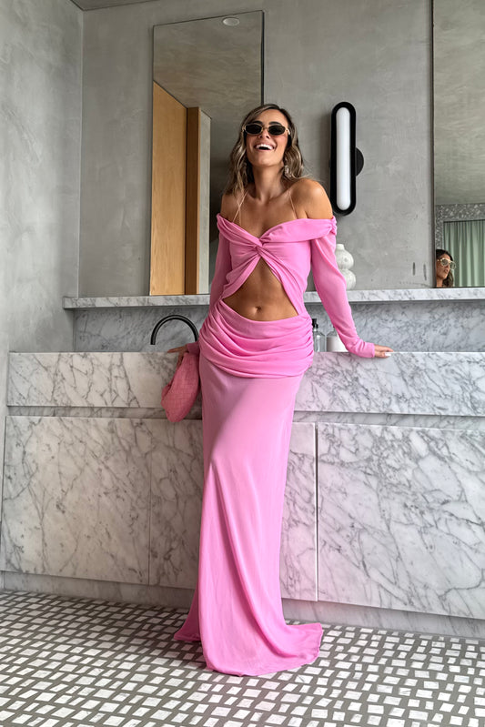 Emily Gown Candy Pink by Natalie Rolt – A trendy, ethereal georgette gown with off-shoulder draping and fluid bias cut, perfect for special occasions and statement-making moments.