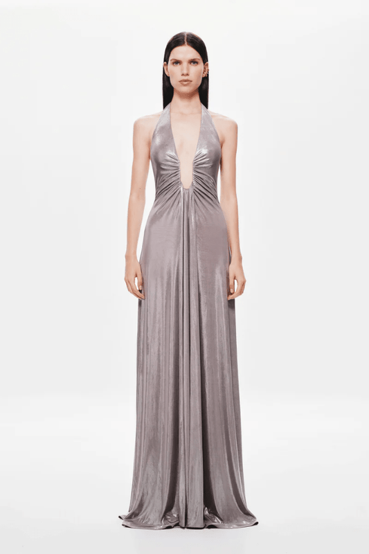 Jennifer Foil Jersey Dress Cinder by Misha – Trendy slim-fit maxi with deep V halter neckline, gathered waist, and cascading sash, perfect for glamorous day-to-evening occasions.
