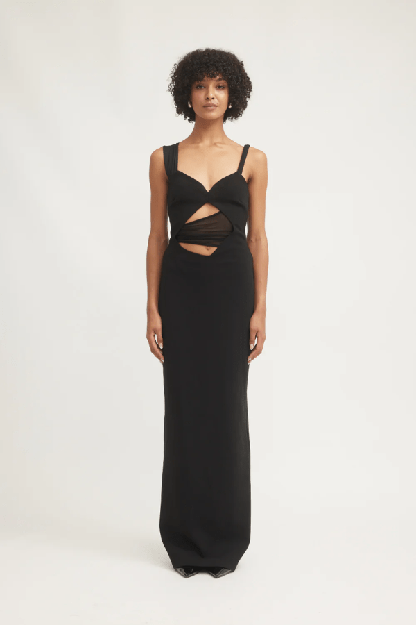 Madeleine Dress Black by Tojhà – A viral double-bonded crepe maxi with asymmetric straps, curved cut-out, and layered mesh, perfect for elegant evening events.