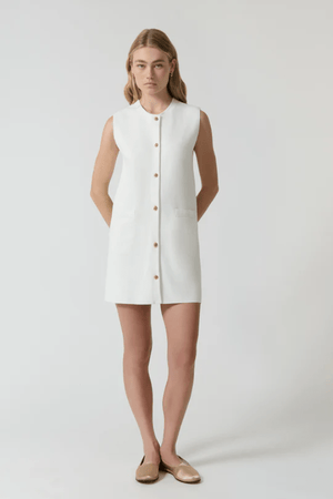 Nanda Dress White by Onte – A chic, timeless sleeveless mini shift in heavy Milano knit with gold knot buttons and welt pockets, perfect for effortless day-to-night style.