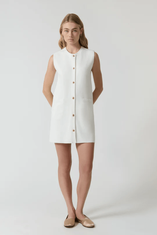 Nanda Dress White by Onte – A chic, timeless sleeveless mini shift in heavy Milano knit with gold knot buttons and welt pockets, perfect for effortless day-to-night style.