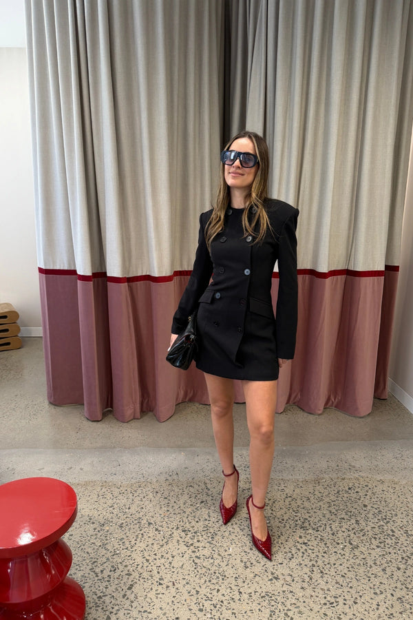 Even Odds Mini Dress Black by Mossman - tailored mini dress with structured shoulders and double breasted detail, designed for a sharp modern silhouette.