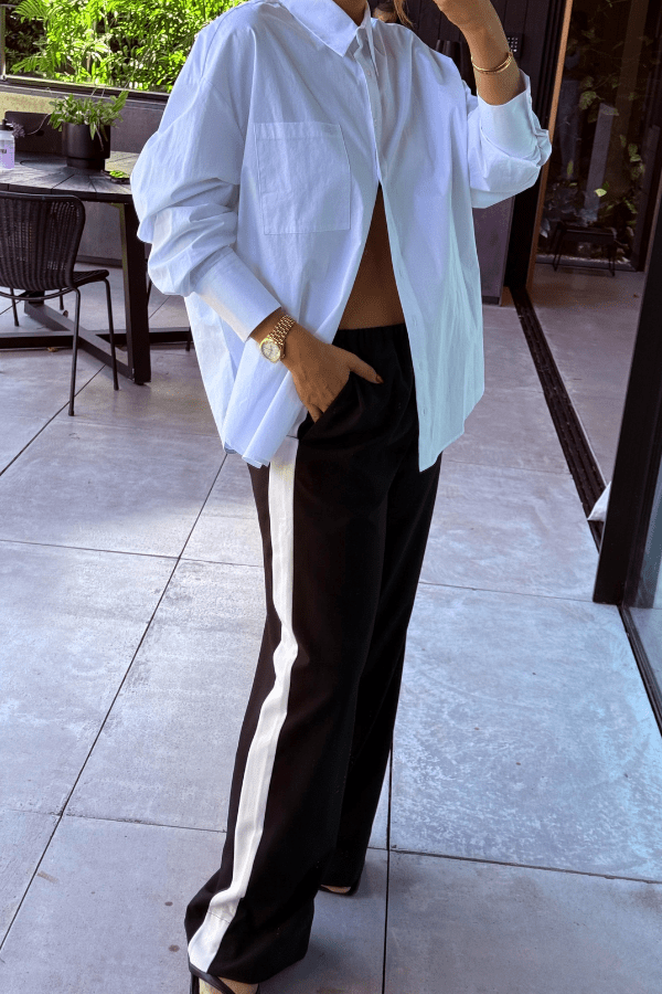 Boston Shirt White by Sneaky Link – Crisp oversized cotton poplin with button front and signature snake embroidery. Perfect for viral classic and casual-chic looks.