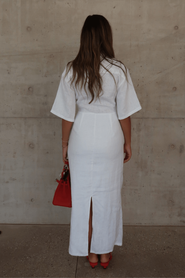 Lefka Midi Dress White by Sneaky Link – Breezy 100% linen midi with button-front and flattering tucks. Perfect for trendy summer strolls or viral lunch dates.