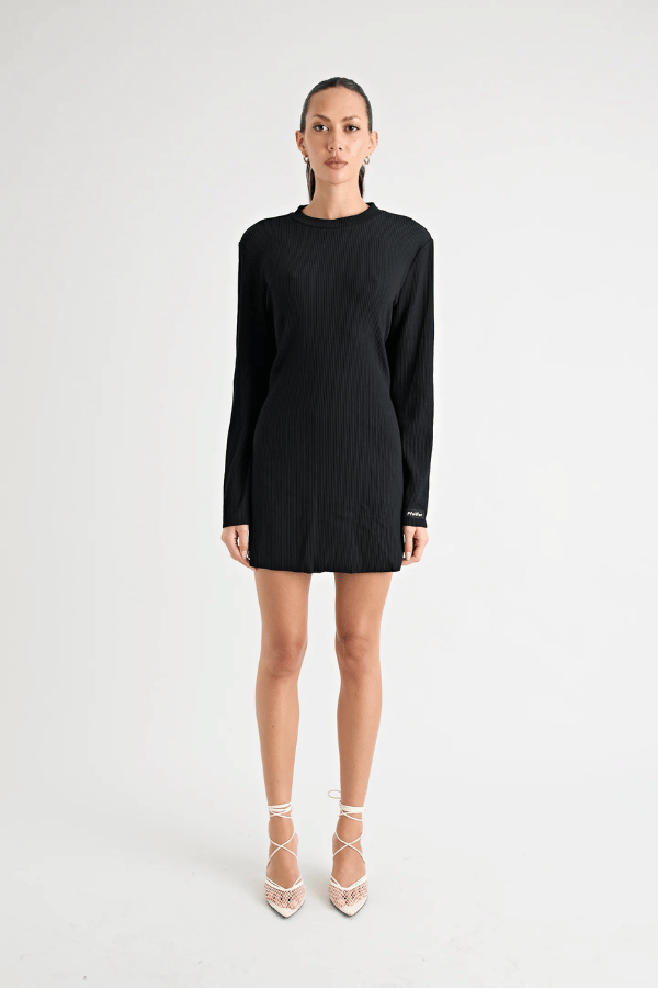 Fairbank Rib Dress Black by Pfeiffer – A trendy, comfortable ribbed bamboo dress with high raw-edge neckline, full sleeves, and versatile two-part back design. Perfect for chic casual wear or layering in cooler seasons.