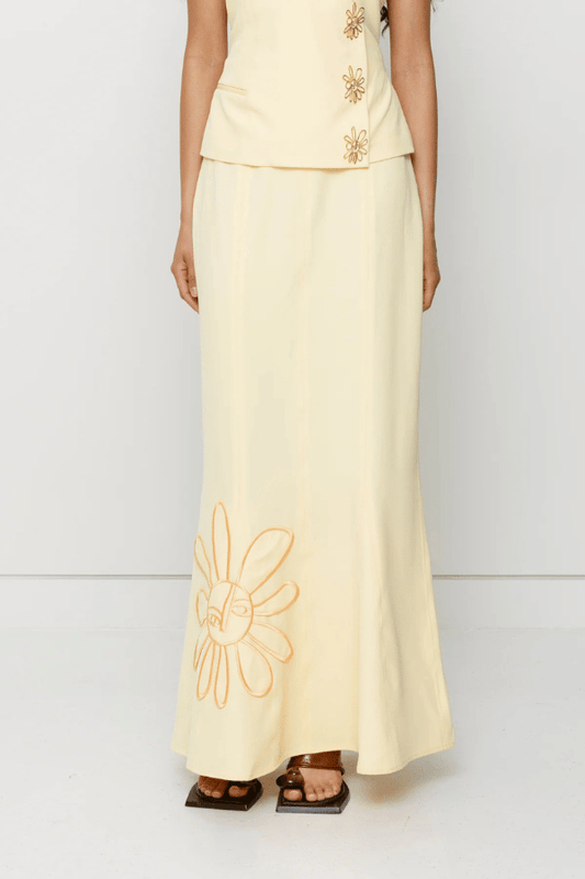 Inka Maxi Skirt Butter by The Wolf Gang, a flared godet midi with custom embroidery. Perfect for standout sets or sunny solo moments.