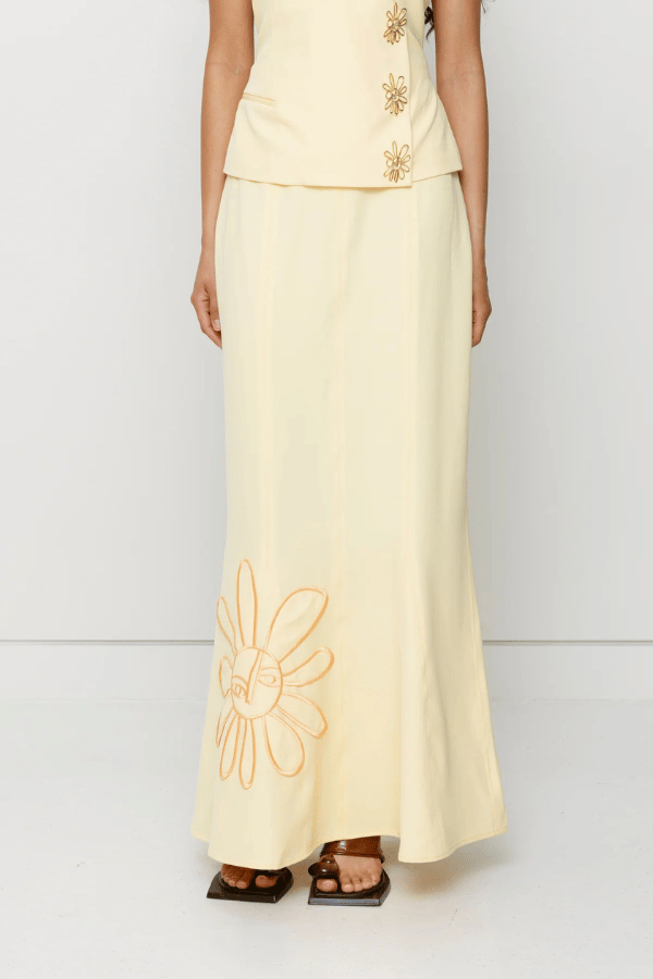 Inka Maxi Skirt Butter by The Wolf Gang, a flared godet midi with custom embroidery. Perfect for standout sets or sunny solo moments.