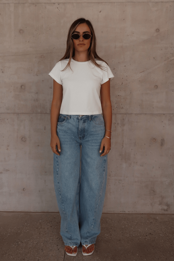 Claudia Baby Tee White by Sneaky Link – A relaxed, cropped tee crafted from a soft viscose-spandex blend for comfort and stretch. Perfect casual chic with short sleeves.