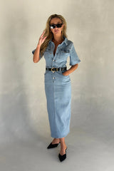 Light blue denim midi dress with short sleeves and a button-down front, styled with a relaxed fit.