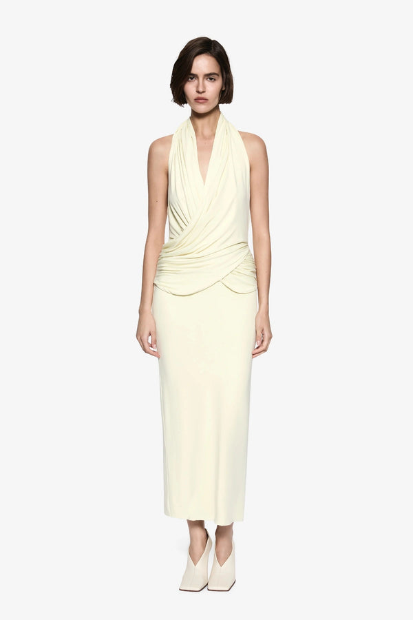 The Cabana Cupro Dress by MISHA, a lemon midi with halter neckline and soft hip drape. Perfect for weddings or refined summer events.