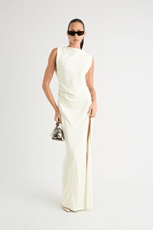 Matia Gown Butter by Pfeiffer – A timeless maxi with a boat neckline, low back, and adjustable strap. Perfect for elegant events and special occasions.