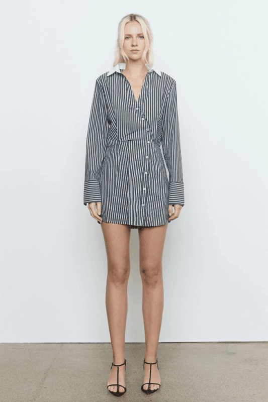 Laia Shirt Dress Black Stripe by Sovere Studio – A trendy cotton blend shirt dress with asymmetric placket, flattering waist tucks, and contrast collar. Perfect for casual to semi-formal looks.