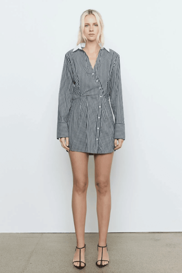 Laia Shirt Dress Black Stripe by Sovere Studio – A trendy cotton blend shirt dress with asymmetric placket, flattering waist tucks, and contrast collar. Perfect for casual to semi-formal looks.