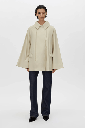 Memento Raincoat Alabaster by Camilla and Marc – double-breasted with hood and monogram detail, perfect for stylish rainy days or light layering.
