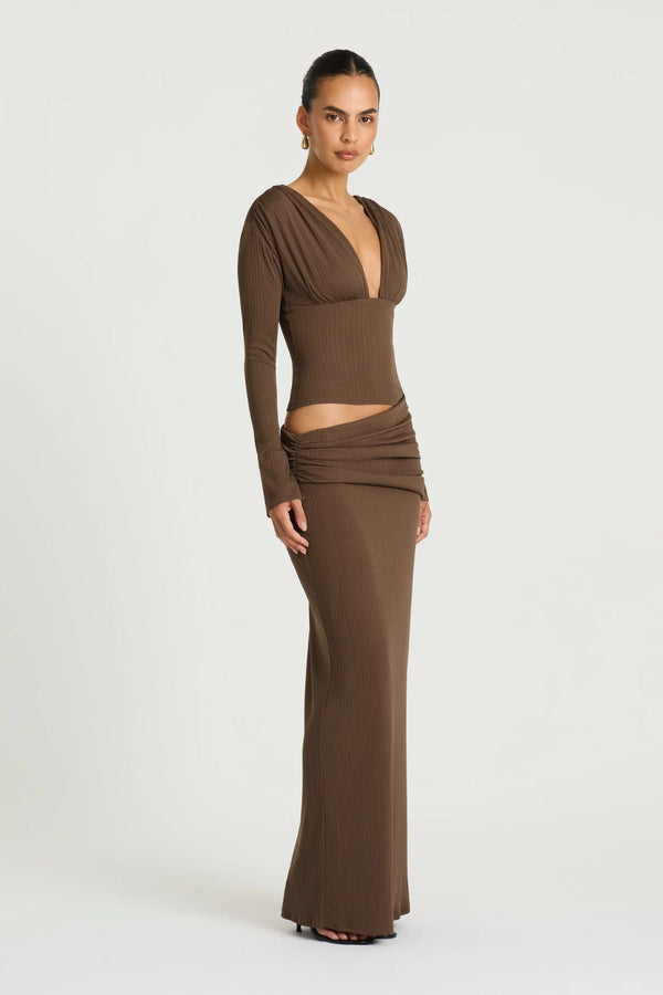 Agnes Maxi Dress in Chocolate by Benni, a ribbed long-sleeve maxi with deep plunge neckline, gathered bust, and subtle hip draping.