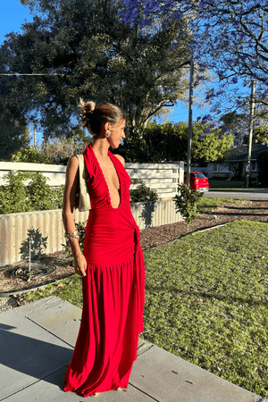 Dakota Pure Red by Deconduarte – Trendy fluid jersey dress with elastic neckline, fitted belt skirt, side slit, and lettuce-edge hem, perfect for confident, carefree occasions.