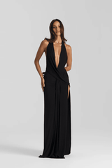 Winona Gown Black by Natalie Rolt, halter neckline, asymmetric draped bust overlay, open back, side split, gathered waterfall skirt, full-length hem, elevated jersey. Dry clean only.