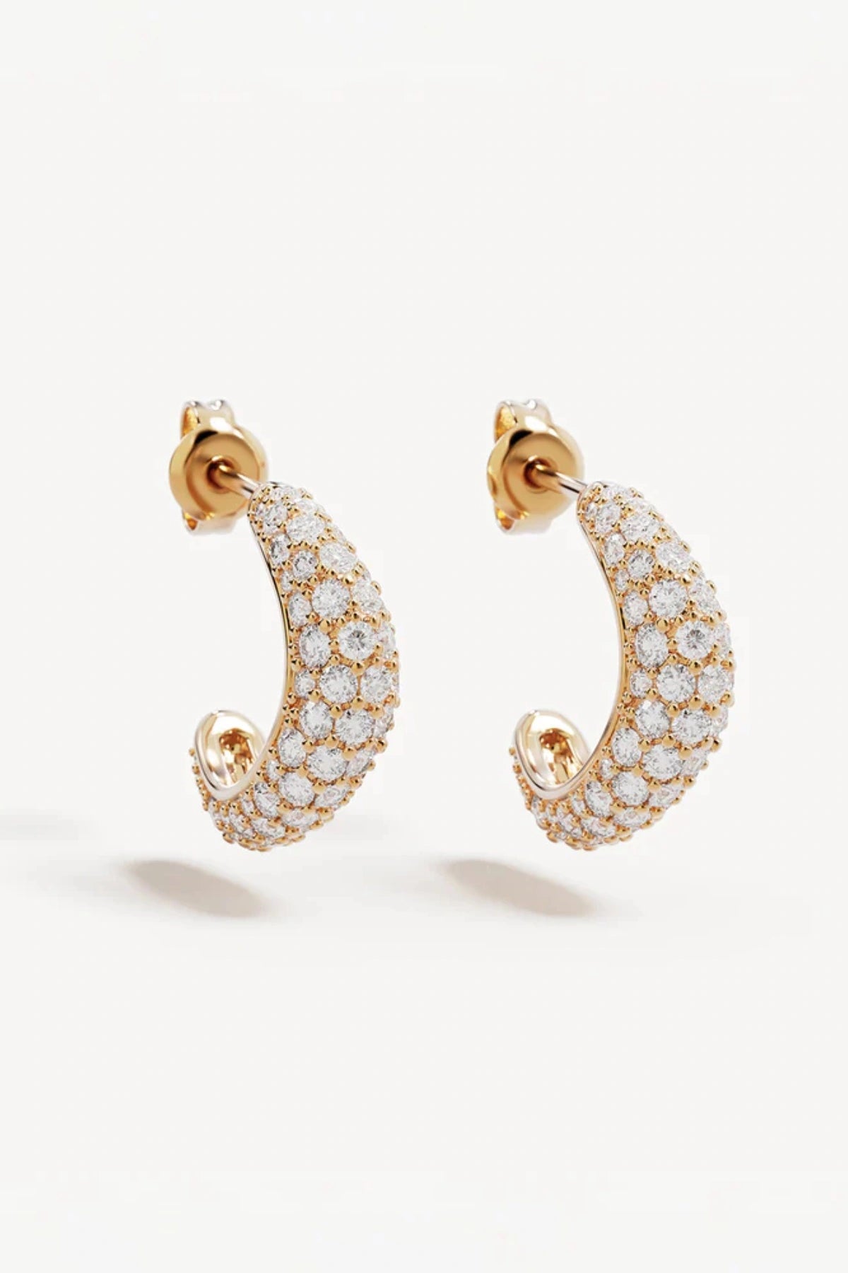 Crystal Wave Hoops by by charlotte — gold vermeil wave-shaped hoops with pavé crystals, perfect for elegant event styling.
