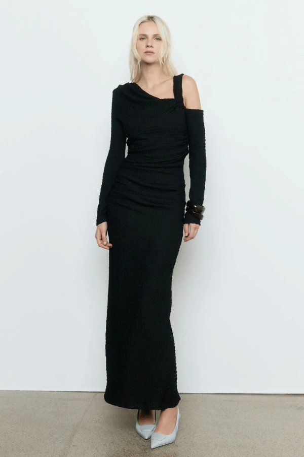 Solstice Dress Black by Sovere – Trendy fitted midi with asymmetric neckline, off-shoulder sleeve, and pleat details, perfect for elegant evening occasions and standout style.