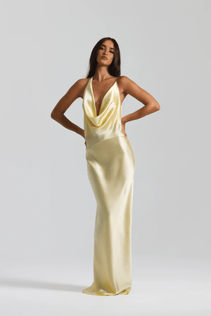 Gabi Gown Lemon by Natalie Rolt – A trendy bias-cut silk gown with an elegant asymmetric silhouette, open back, and delicate ties, perfect for special occasions.