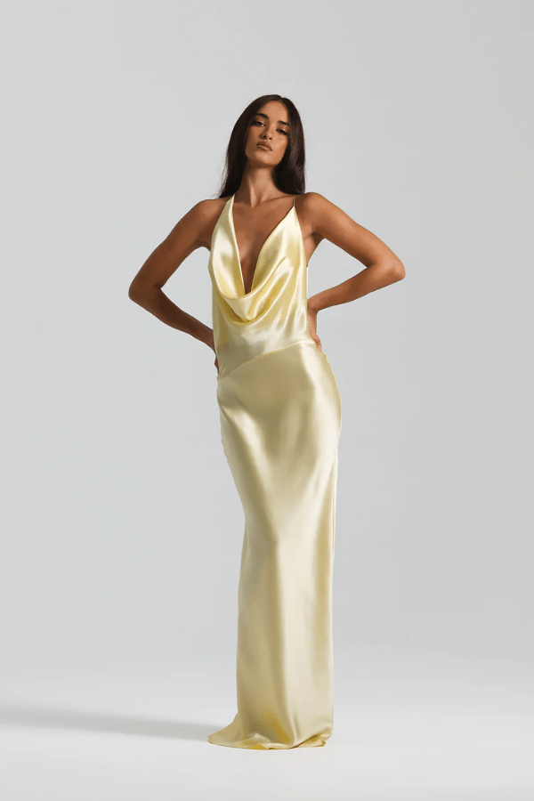 Gabi Gown Lemon by Natalie Rolt – A trendy bias-cut silk gown with an elegant asymmetric silhouette, open back, and delicate ties, perfect for special occasions.