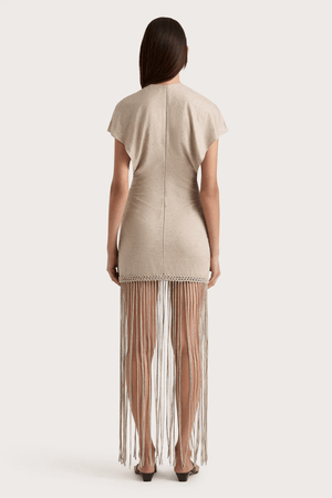 Ines Fringe Dress Oatmeal by Faithfull the Brand – Sheer linen mini with macrame hem, fringe skirt, and batwing sleeves.