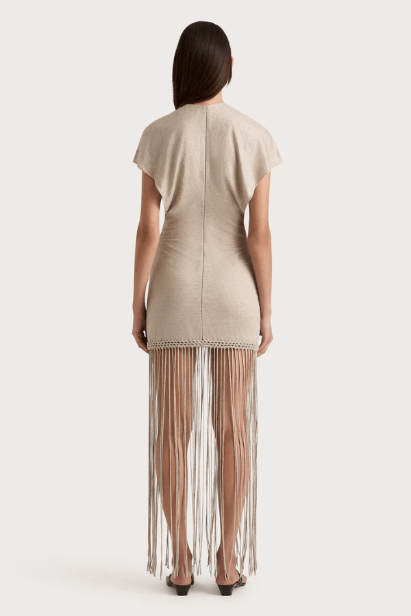 Ines Fringe Dress Oatmeal by Faithfull the Brand – Sheer linen mini with macrame hem, fringe skirt, and batwing sleeves.