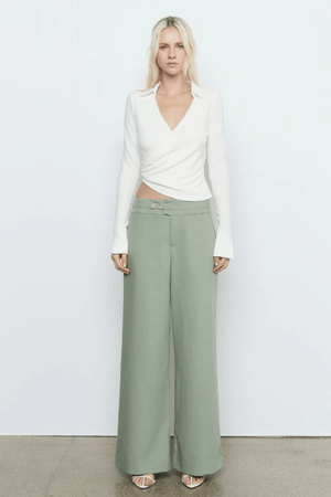 Emile Top White by Sovere — A fitted long-sleeve top in textured stretch fabric featuring a fixed wrap front, structured collar, wide split cuffs, and side gathers for a flattering silhouette. Fully lined for smooth wear and effortless sophistication.