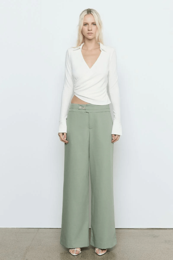 Emile Top White by Sovere — A fitted long-sleeve top in textured stretch fabric featuring a fixed wrap front, structured collar, wide split cuffs, and side gathers for a flattering silhouette. Fully lined for smooth wear and effortless sophistication.