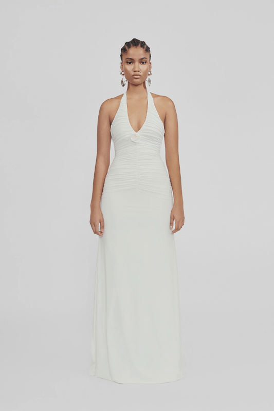 Roman Off White by Maygel Coronel – Elegant halter dress with deep V-neck, flattering ruching, and delicate 3D floral detail, perfect for refined events and celebrations.