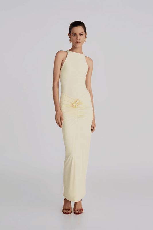 Alquimia Maxi Dress Vanilla by Maygel Coronel – A sculpting open-back maxi with ruched front and bold handmade floral detail.