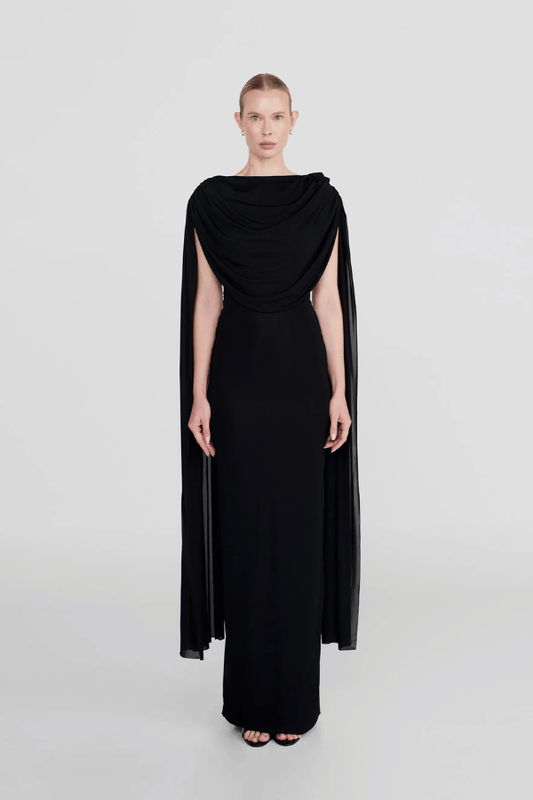 Batista Basalto by Maygel Coronel – An elegant long dress with a cowl scoop neckline, flowing shoulder sashes, and a sleek column silhouette, perfect for sophisticated evening events and making a timeless, statuesque statement.