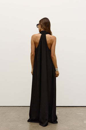 Willow Dress by Bayse, a sleek halter-neck maxi with fluid drape and side pockets, perfect for effortless day-to-evening wear.