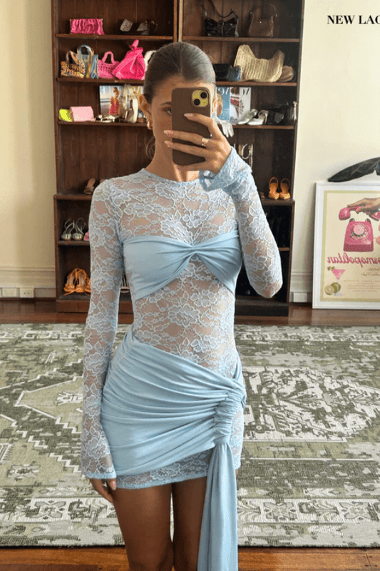 Ortigia Baby Blue by Decon Duarte – A trendy sheer stretch lace dress in soft powder blue, featuring a backless design and adjustable mini skirt. Perfect for year-round stylish occasions.