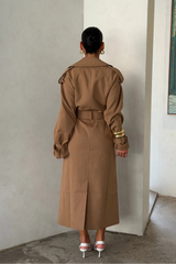 Trench Coat Tan by Sneaky Link – A timeless oversized coat in rich tan polyester, featuring classic details and subtle snake embroidery. Perfect for stylish transitional days.