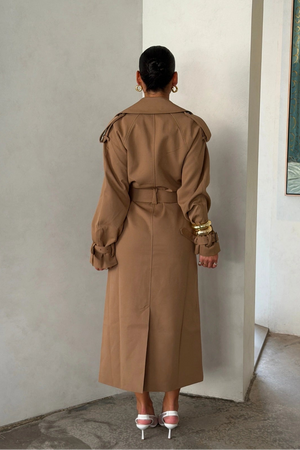 Trench Coat Tan by Sneaky Link – A timeless oversized coat in rich tan polyester, featuring classic details and subtle snake embroidery. Perfect for stylish transitional days.