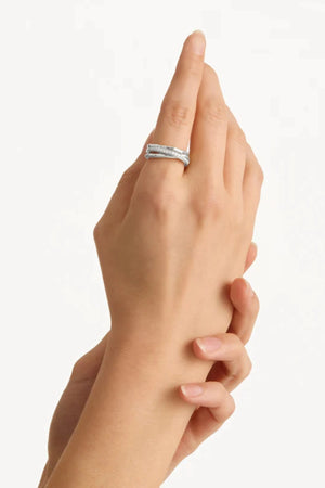 Entwined Hearts Ring by By Charlotte — a sterling silver double-band ring with intertwined crystal details, perfect for timeless everyday wear.