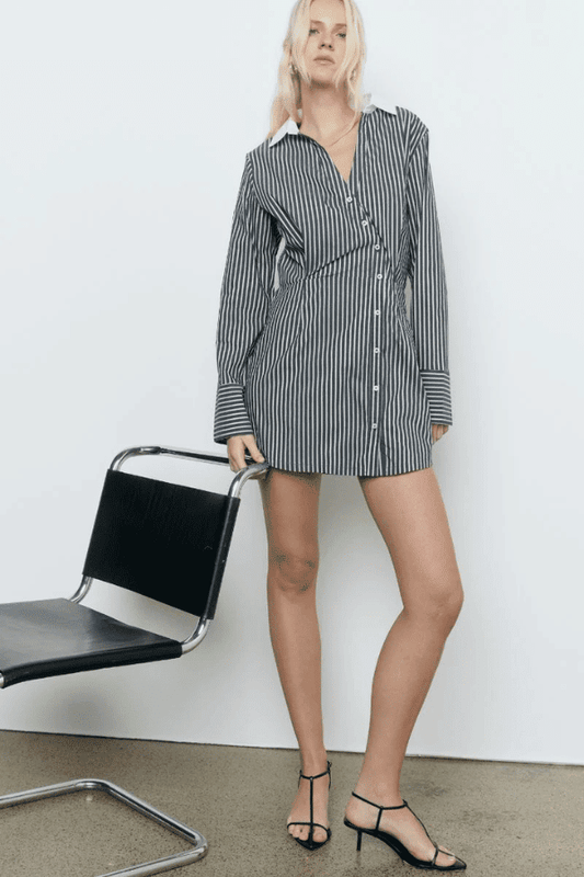 Laia Shirt Dress Black Stripe by Sovere Studio – A trendy cotton blend shirt dress with asymmetric placket, flattering waist tucks, and contrast collar. Perfect for casual to semi-formal looks.